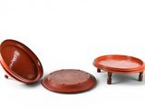 two red plates and a brown plate on a white surface