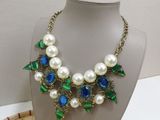 necklace and earring set with blue and white pearls and green leaves