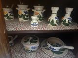 many vases and bowls on a shelf in a cabinet