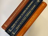 trois livres sont empilés sur une table