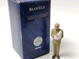 a figurine of a man holding a baby in front of a box