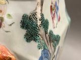 a vase that has a bird and flowers on it