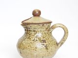 cream and brown ceramic teapot with wooden lid on white background