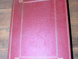 un vieux livre rouge posé sur une table en bois