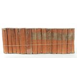 several old books stacked on top of each other on a white surface