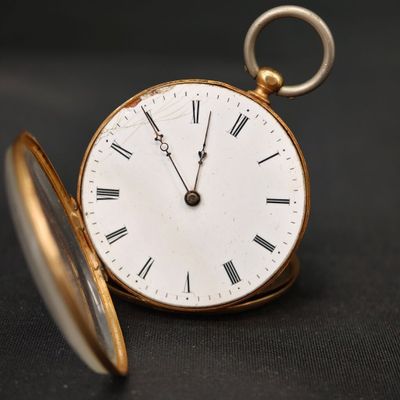 une montre de poche en or avec des chiffres romains