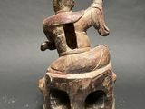 an image of a statue of a man sitting on top of a tree stump