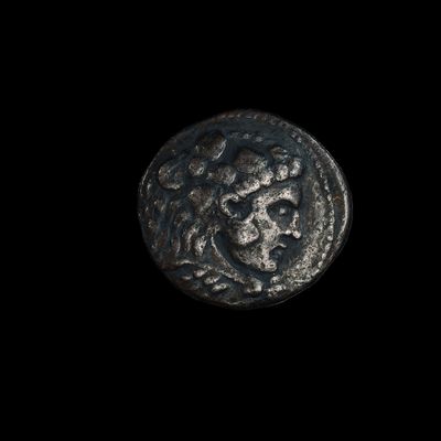 l'image d'une pièce de monnaie sur laquelle figure un visage, sur fond noir