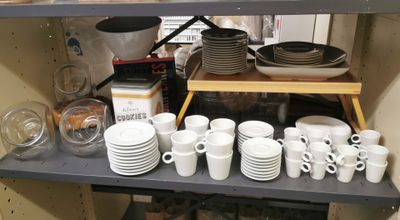many cups and saucers on the shelves in the kitchen