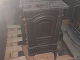 a black stove sitting on a pallet in a room