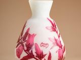 a white vase with pink flowers on it on a brown background
