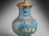 une image représentant un vase bleu et or avec un socle doré