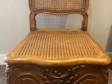 a wooden chair with a wicker seat in a room