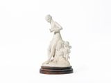 une statue représentant une femme avec un chien, posée sur un socle