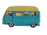 un petit bus en plastique posé sur une surface blanche
