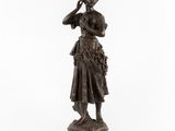 une statue en bronze représentant une femme tenant une fleur à la main