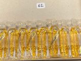 une boîte remplie de flacons en verre contenant des paillettes d'or