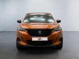 the front view of a orange car parked in a showroom