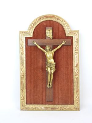 a gold crucif on a red wall with a gold frame