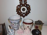 a table with a clock, a mirror, a bowl, and other items on it