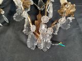 a glass candle holder with flowers on it on a table