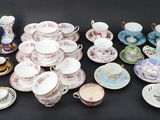 many different types of tea cups and saucers on the table