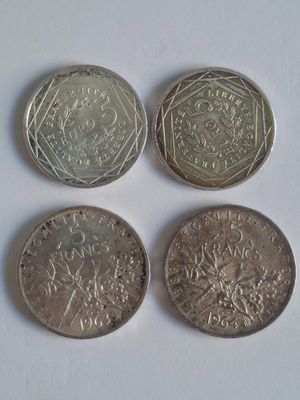 trois pièces d'argent posées l'une sur l'autre sur une surface blanche