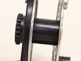 a close up of a metal reel on a white surface