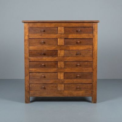 an image of a wooden chest of drawers against a gray background