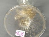 a clear glass vase with a gold decoration on it