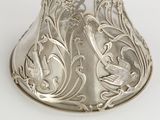 a silver spoon with a bird on it on a white surface