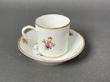 a small cup and saucer sitting on a table