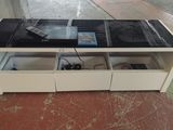 un meuble TV blanc avec un plateau noir et des tiroirs