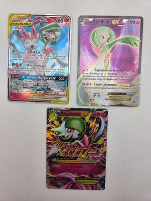 trois cartes Pokémon différentes posées sur une surface blanche