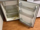 a small refrigerator that is open and sitting on the floor