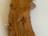 une statue en bois représentant une femme tenant un oiseau