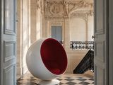 une chaise boule rouge et blanche au milieu d'une pièce