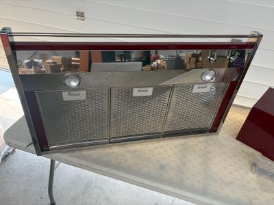 an image of a silver and red oven on a table