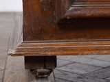 close up of the legs of a wooden cabinet on a hard wood floor