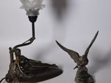 une rose blanche posée sur une table, à côté d'une lampe
