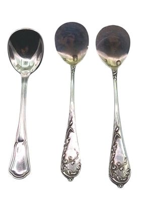 trois cuillères en argent et une cuillère avec un manche, sur fond blanc