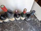 several bottles of wine are lined up in a row on the floor