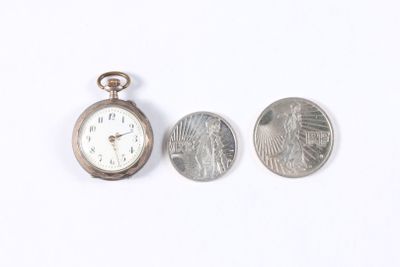 a small silver pocket watch next to a quarter