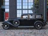 a old black car parked in front of a building