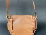a tan leather purse with a metal handle and a metal clasp