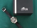 the watch is sitting on the green cloth next to the box
