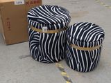 two bags of luggage sitting on the ground next to a cardboard box