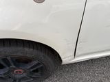 a white car with a hole in the side of it