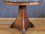 une table avec un plateau en marbre posée sur un parquet