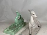 two figurines of a horse and a horse on a table